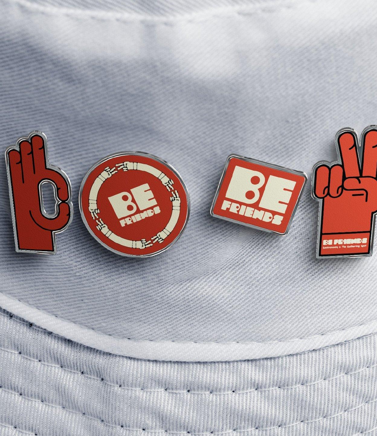 Be Friends enamel pins on a canvas bucket hat